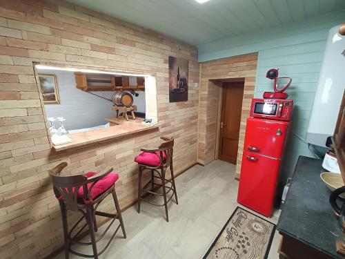 eine Küche mit einem roten Kühlschrank und 2 Hockern in der Unterkunft Trombitás Vendégház in Tarján
