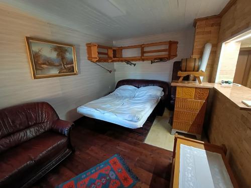 ein kleines Zimmer mit einem Bett und einem Sofa in der Unterkunft Trombitás Vendégház in Tarján