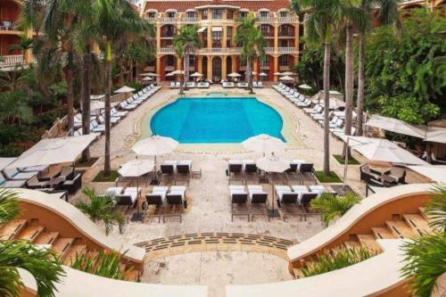 una piscina con sedie e ombrelloni di fronte a un resort di Bovedas de Sofitel Santa Clara a Cartagena de Indias