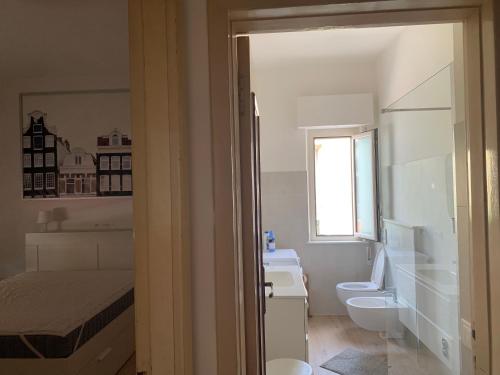 bagno bianco con servizi igienici e lavandino di Beachhouse Pineto zona Corfu a Pineto