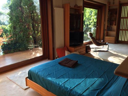 une chambre avec un lit bleu et une grande fenêtre dans l'établissement Villa La Source, à Saint-Jean