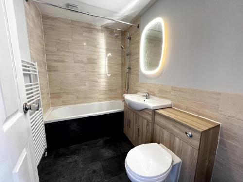 een badkamer met een wastafel, een toilet en een bad bij The Springfield Hotel in Fairbourne
