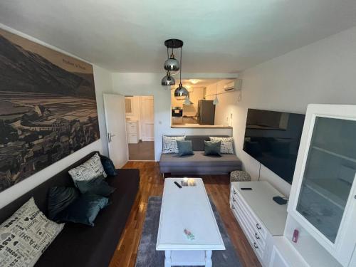 a living room with a couch and a table at Main Street Apartment in Ston