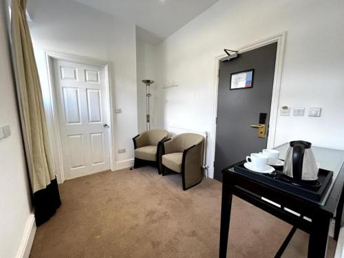 een kamer met een tafel, een stoel en een deur bij The Springfield Hotel in Fairbourne