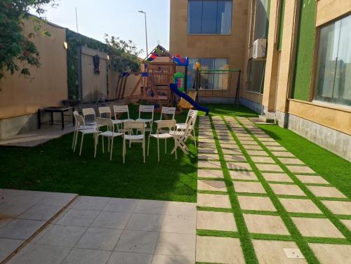 a patio with a table and chairs and a playground at شاليه كادي cady resort in Al Khobar