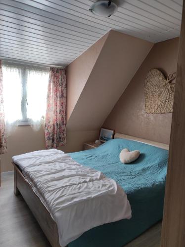 une chambre avec un lit avec un oreiller dessus dans l'établissement CHEZ ISA - Maison à 2 km de la plage de Le Portel 62, à Outreau