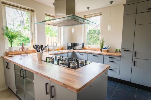 a kitchen with a counter with a stove top oven at Newly renovated luxurious Villa / hottub / sauna / 7 bedrooms in Zeewolde