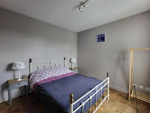 une chambre avec un lit avec une couette violette dans l'établissement La libellule Pelaude Appartement 4-6 personnes avec terrasse, à Eymoutiers