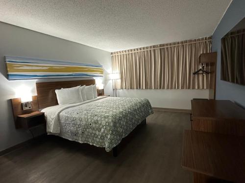 a hotel room with a bed and a window at HomeTowne Studios by Red Roof & Conference Center Cortland in Cortland