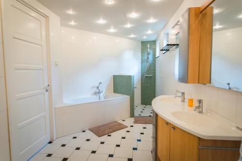 a bathroom with a sink and a tub and a shower at Newly renovated luxurious Villa / hottub / sauna / 7 bedrooms in Zeewolde