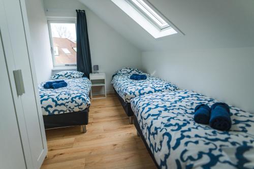 a bedroom with two beds with blue pillows and a window at Newly renovated luxurious Villa / hottub / sauna / 7 bedrooms in Zeewolde