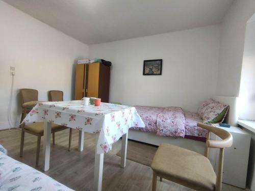 a room with a table and a bed and a table and chairs at Cozy hotel with breakfast in Subotica