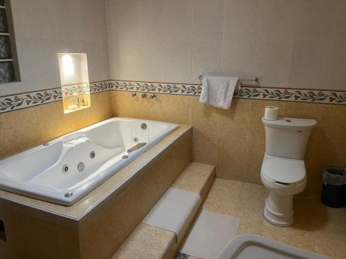 La salle de bains est pourvue d'une baignoire et de toilettes. dans l'établissement Misión Vizcaya Hospedaje, à Durango