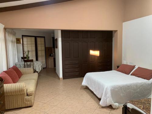 - une chambre avec un lit et un salon avec un canapé dans l'établissement Apartamento con jardin, à Cochabamba