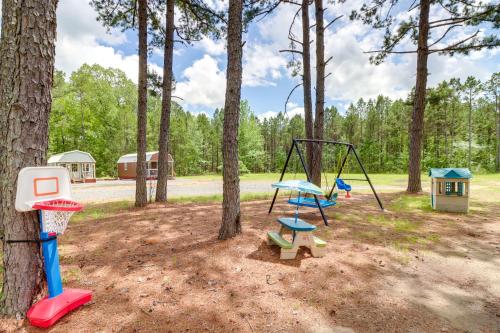a playground with a swing in the woods at Tree-Lined Higden Retreat Close to Parks and Trails in Fairfield Bay