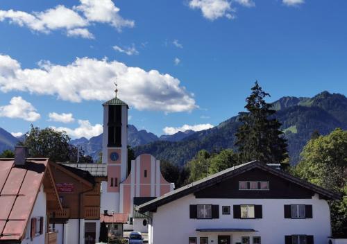 una piccola città con una torre dell'orologio in montagna di Ferienwohnung Almwiese a Oberstdorf