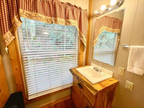 a bathroom with a sink and a window at Cute Cabin creek & Firepit #12 in Helen