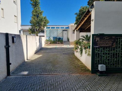 une allée menant à une maison avec un portail dans l'établissement B&B Castelluccio, à Villafranca Tirrena