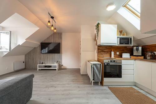 une cuisine avec des armoires blanches et un canapé dans une pièce dans l'établissement Logement 7 personnes près de Disney & Paris, à Chanteloup-en-Brie