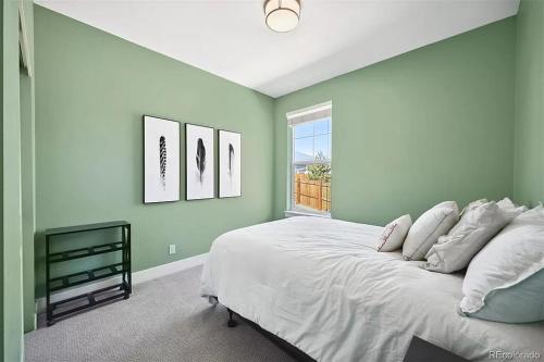- une chambre avec des murs verts et un lit avec une fenêtre dans l'établissement 4BR Home close to Airport, à Aurora