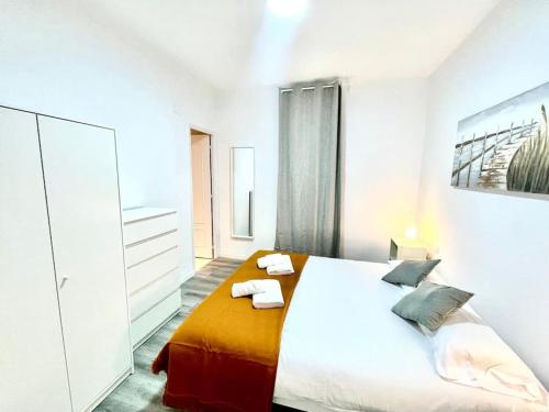 トッサ・デ・マールにあるSeaHomes Vacations - CENTRIC APT TOSSA DE MARの白いベッドルーム(大型ベッド、タオル付)