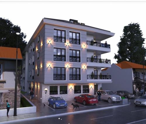 a building with two cars parked in front of it at Apartman ARISTEA in Arandjelovac