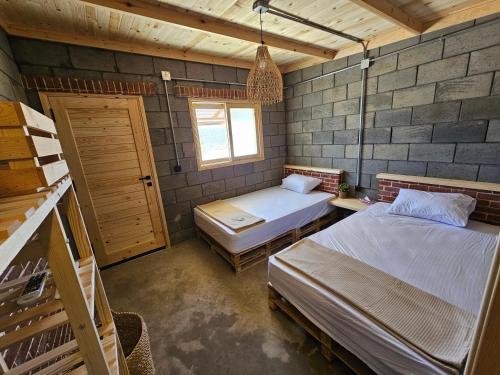 een slaapkamer met 2 bedden en een raam bij Lily's motel in El Alamein