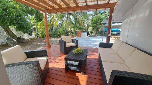 a patio with couches and chairs on a wooden deck at MOOREA - Fare Manoa Manava in Hauru