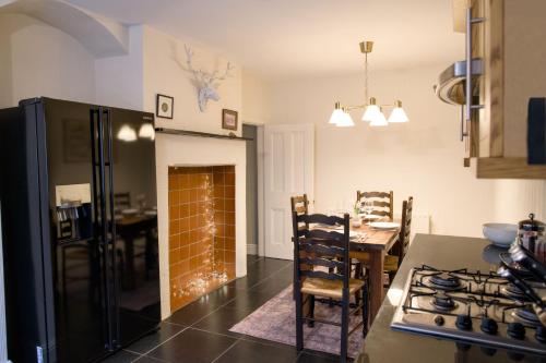 a kitchen with a table and a fireplace in a room at The Beeches - Chatsworth Apartment No 2 - Sleeps 4 in Baslow