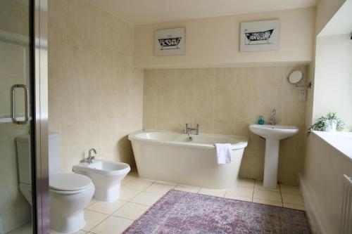 a bathroom with a tub and a toilet and a sink at The Beeches - Chatsworth Apartment No 2 - Sleeps 4 in Baslow