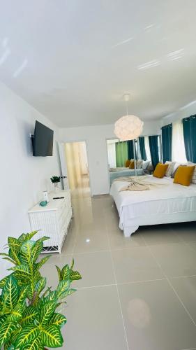 a large white room with a bed and a tv at Promo Viviendas Sol y Mar in Juan Dolio