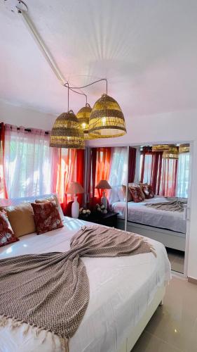 a bedroom with two beds and two lamps and windows at Promo Viviendas Sol y Mar in Juan Dolio