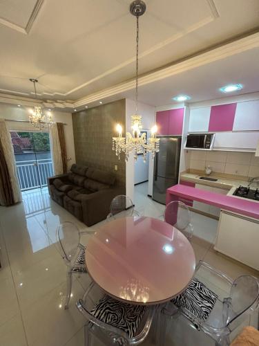 cocina y sala de estar con mesa y sillas en Apartamento inteiro muito aconchegante en Joinville