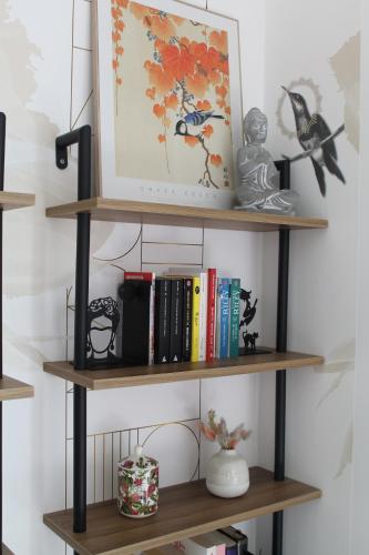 a shelf with books and other items on it at Le jardin de Clémentine in Wingersheim