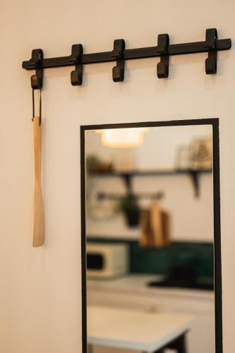 a mirror hanging on a wall with a wooden stick at MooDee Suite - Piata Sfatului in Braşov