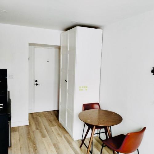 een kamer met een tafel en stoelen en een kast bij La maisonnette in Montreal