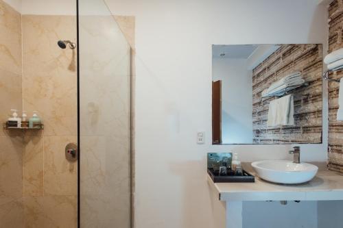 uma casa de banho com um lavatório e um chuveiro em Hotel de Sal Luna Salada em Colchani