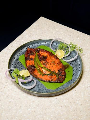 a plate of food with meat and vegetables on a table at InstaFeel Hotel in Navi Mumbai