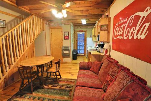 a living room with a coca cola sign on the wall at Mountain Cabin in woods 3 minutes to Helen #13 in Helen