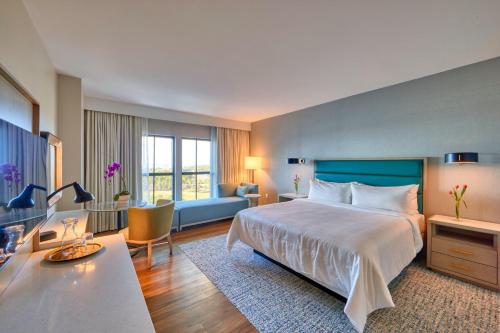 une chambre d'hôtel avec un lit et un canapé dans l'établissement Hotel Effie Sandestin Resort, Autograph Collection, à Destin