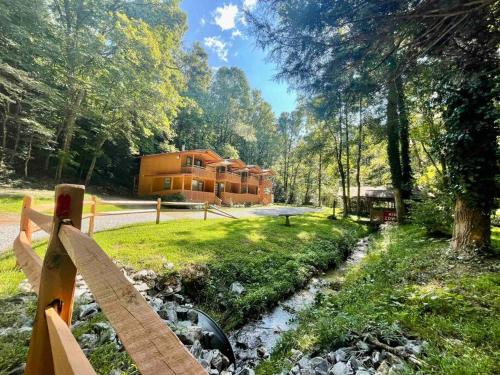 a house in the woods with a fence and a creek at Mountain Cabin in woods 3 minutes to Helen #13 in Helen