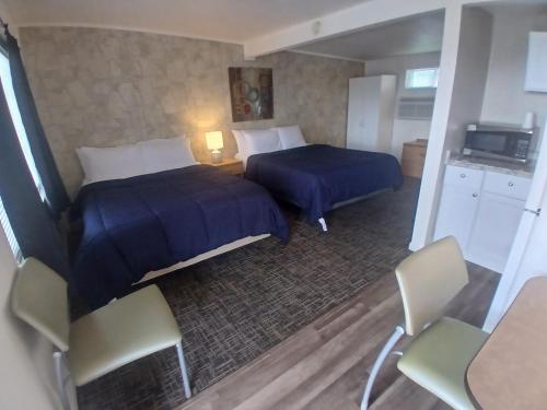 um quarto de hotel com duas camas e uma mesa e cadeiras em Silver Lakes Inn em Hayden