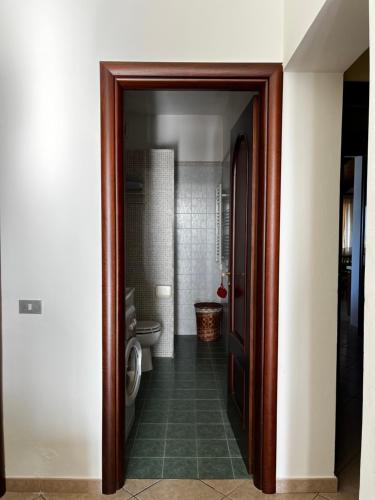 une porte menant à une salle de bains pourvue de toilettes. dans l'établissement Casa del Sole, à Augusta