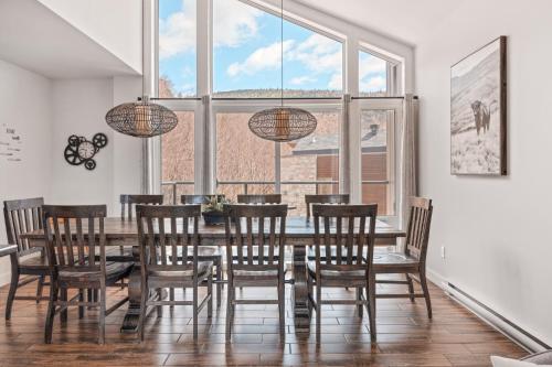 a dining room with a table and chairs and a large window at 17-Chalet à louer à Stoneham in Stoneham