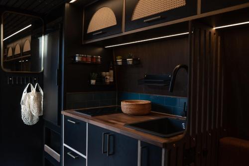 eine Küche mit blauen Schränken und einem Waschbecken in der Unterkunft Trippie Campers in Uphall
