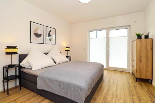 a bedroom with a bed and a large window at LIGHTPLACE - Moderne Apartments in Braunschweig - Balkon - Netflix - Am Kanal in Braunschweig