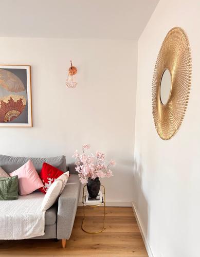 un salon avec un canapé et une table avec des fleurs dans l'établissement Apart 85 m2 proche de paris stade de France parking free, à Groslay