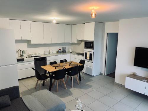 Appartement cosy à Bron في برون: مطبخ وغرفة طعام مع طاولة وكراسي
