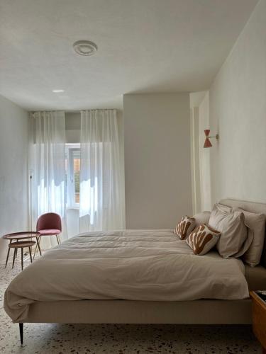 a bedroom with a large bed and a chair at MAISON BENGASI in Civitanova Marche