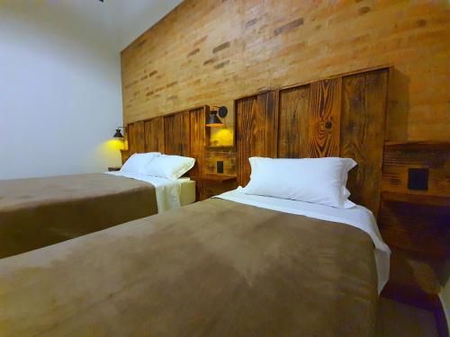 カピトーリオにあるSuítes Capitólio Canastraのベッド2台が備わる木製の壁の客室です。